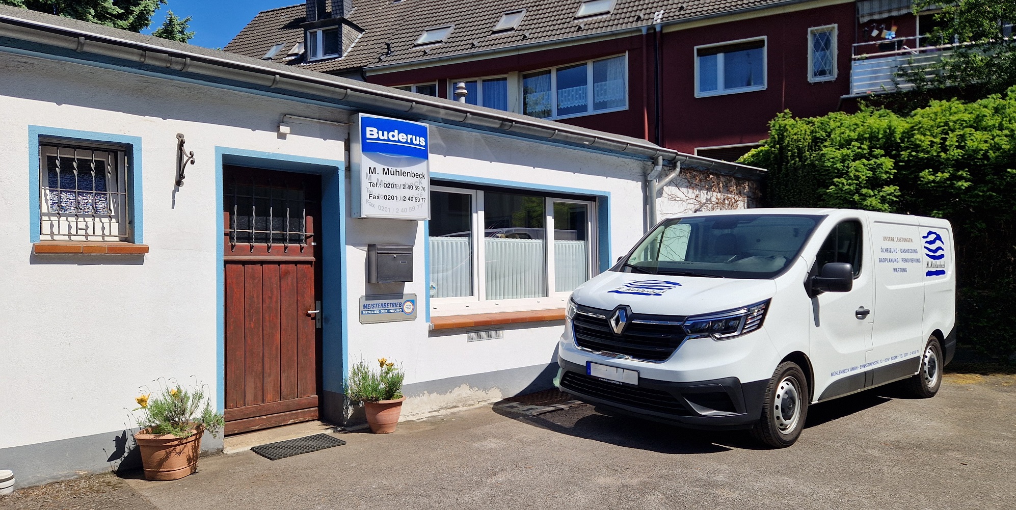 Zu sehen ist das Büro der M. Mühlenbeck GmbH. Ein gelassenes, kleines Häuschen in einem Privatgebiet, daneben steht ein Arbeitsvan.